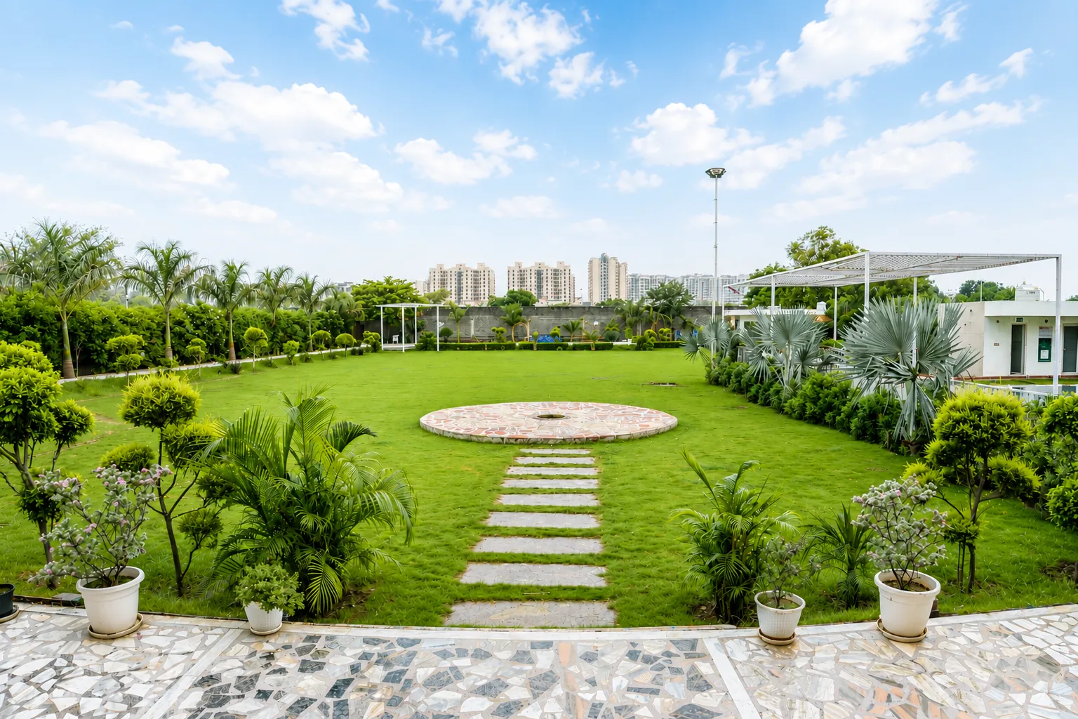 Corporate team outing at a farmhouse near Delhi: a large private lawn with a stone pathway and shaded seating